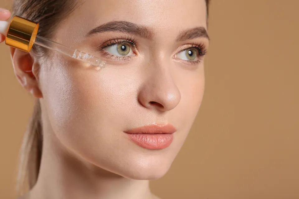 Close portrait of a woman with a skincare dropper near her face