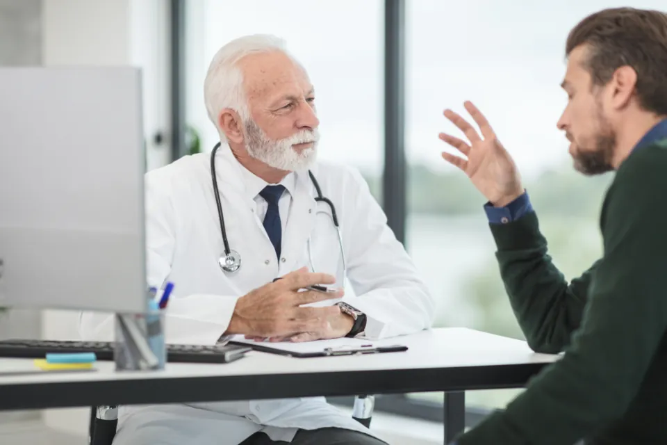 A doctor listens to a patient during a consultation