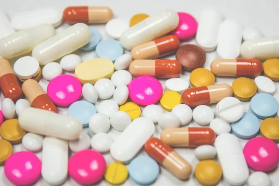 Colourful tablets and capsules on a white surface